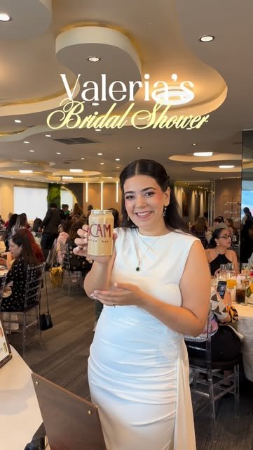 Invitada en un bridal shower sosteniendo una lata de ACAM.